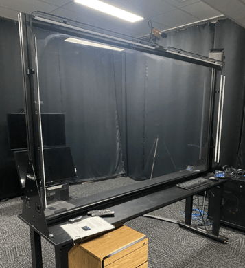 Le tableau transparent lumineux (TTL): une plaque de verre installée à la verticale, entourée d'une bande de lumières DEL qui éclairent les inscriptions faites à l’aide de marqueurs effaçables.