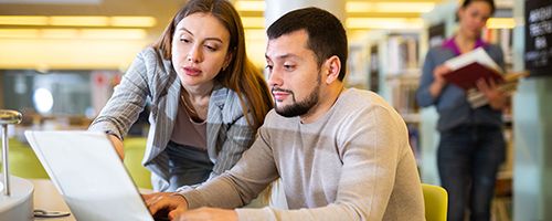 Deux personnes qui conusltent un ordinateur.
