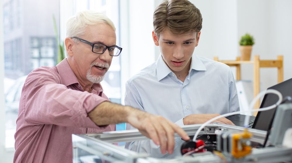 Une personne aide en étudiant dans l'apprentissage d'une fonctionnalité technologique